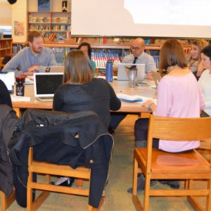 A group of educators meets around a conference table